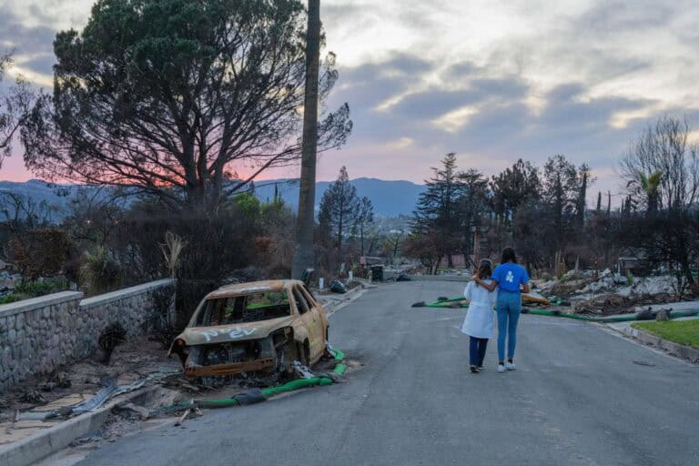 A health care provider and an Americares staff member walk through the destruction in Altadena, Calif., after the 2025 wildfires. Photo by Mike Demas/Americares.
