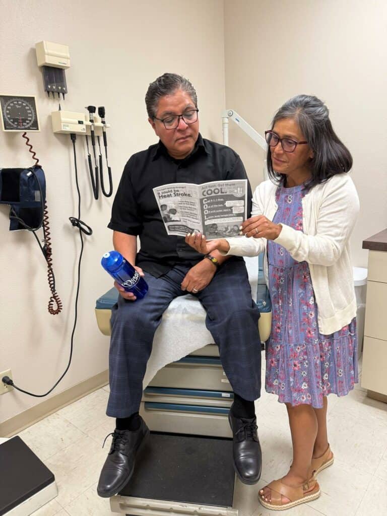 Community Outreach Coordinator Ericka Watson shares heat education materials from Americares, and a water bottle purchased with funding from Americares, with a patient at Grace Clinic in Kennewick, Wash., in August 2025. Photo courtesy of Grace Clinic.