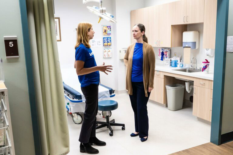 Americares President and CEO Christine Squires (left) speaks with Mercy Urgent Care President and CEO Rachel Sossoman (right) in Asheville, N.C., in October 2024.
